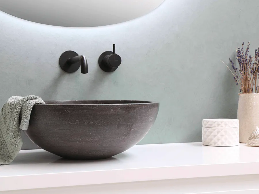 A bathroom sink with a towel hanging from it and a mirror.