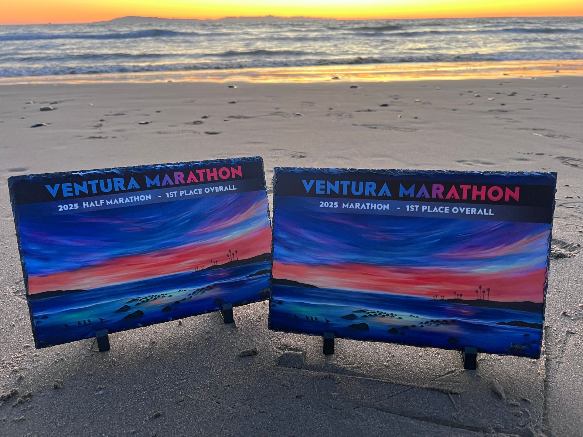 Ventura Marathon slate award tiles sitting on the Ventura Beach.