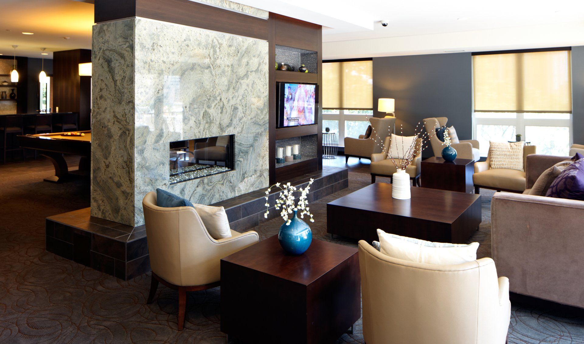 A room with a fireplace and a pool table at 222 Hennepin Apartments.