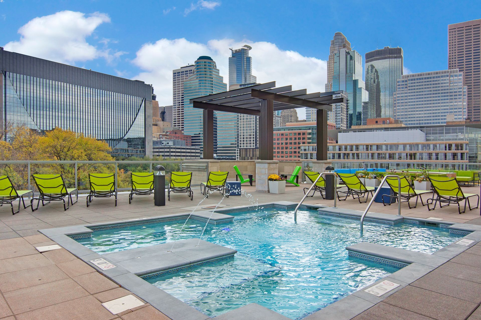 Rooftop pool with lounge chairs and city skyline in the background