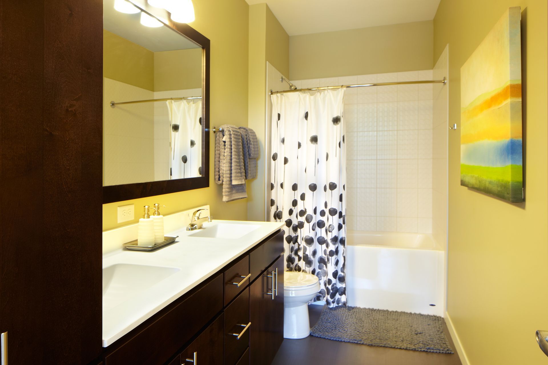Bathroom with dark vanity, large mirror, and white shower curtain with black dots