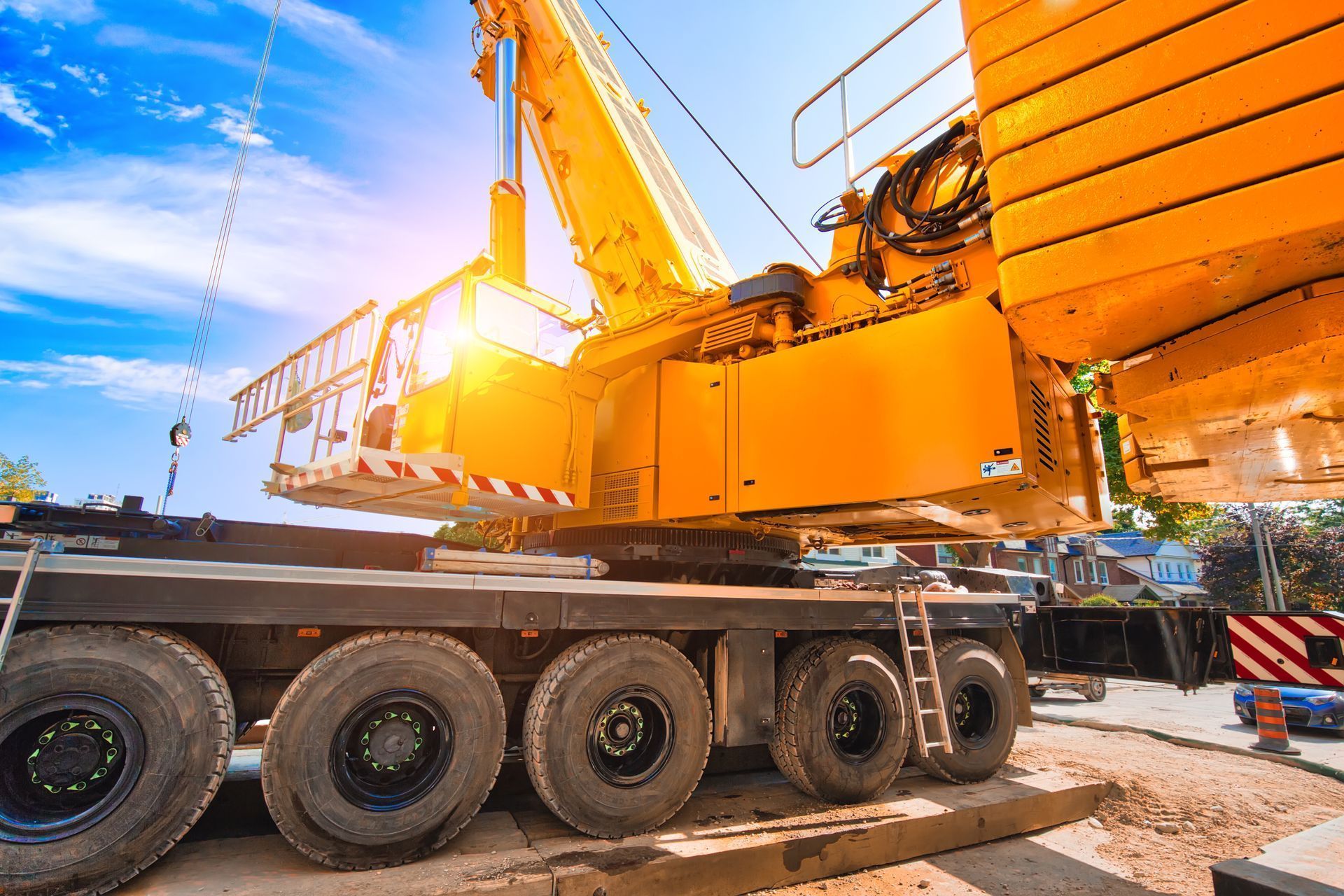 Yellow construction crane on a multi-axle truck under a bright blue sky Yellow construction crane on a multi-axle truck under a bright blue sky
