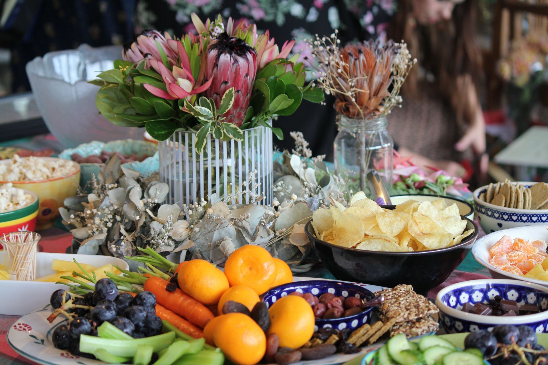 A table topped with plates of food and flowers.