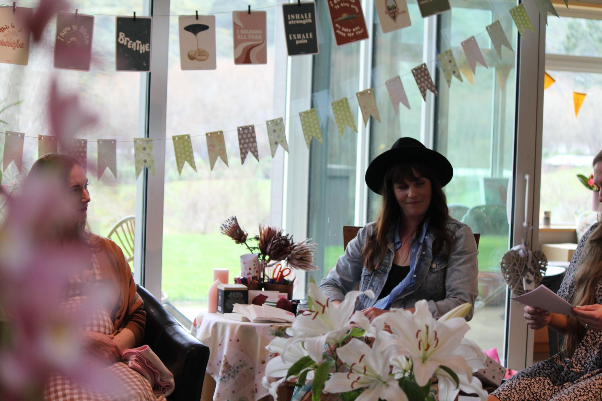 A group of women are sitting at a table with flowers.