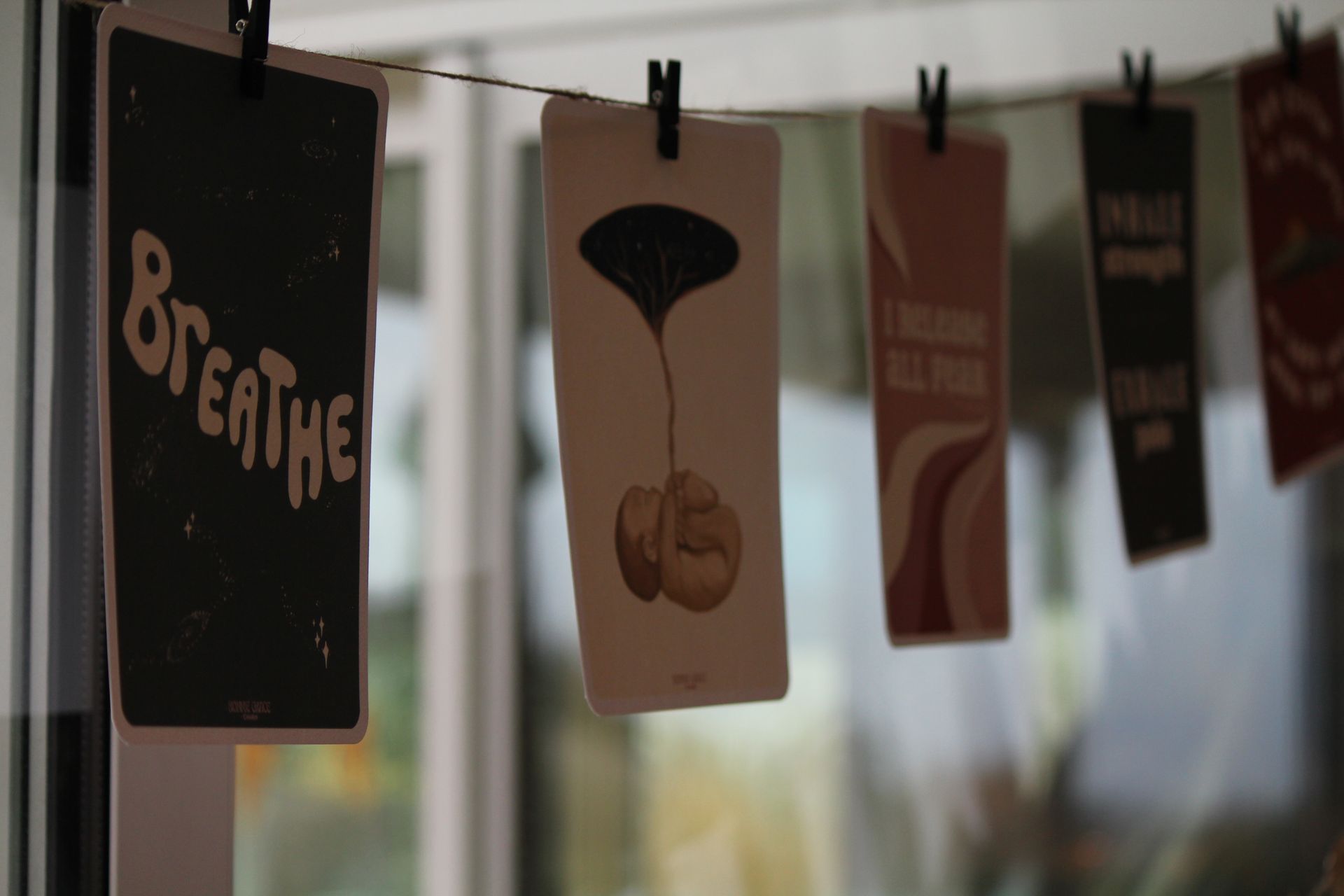 A sign that says breathe hangs on a clothes line