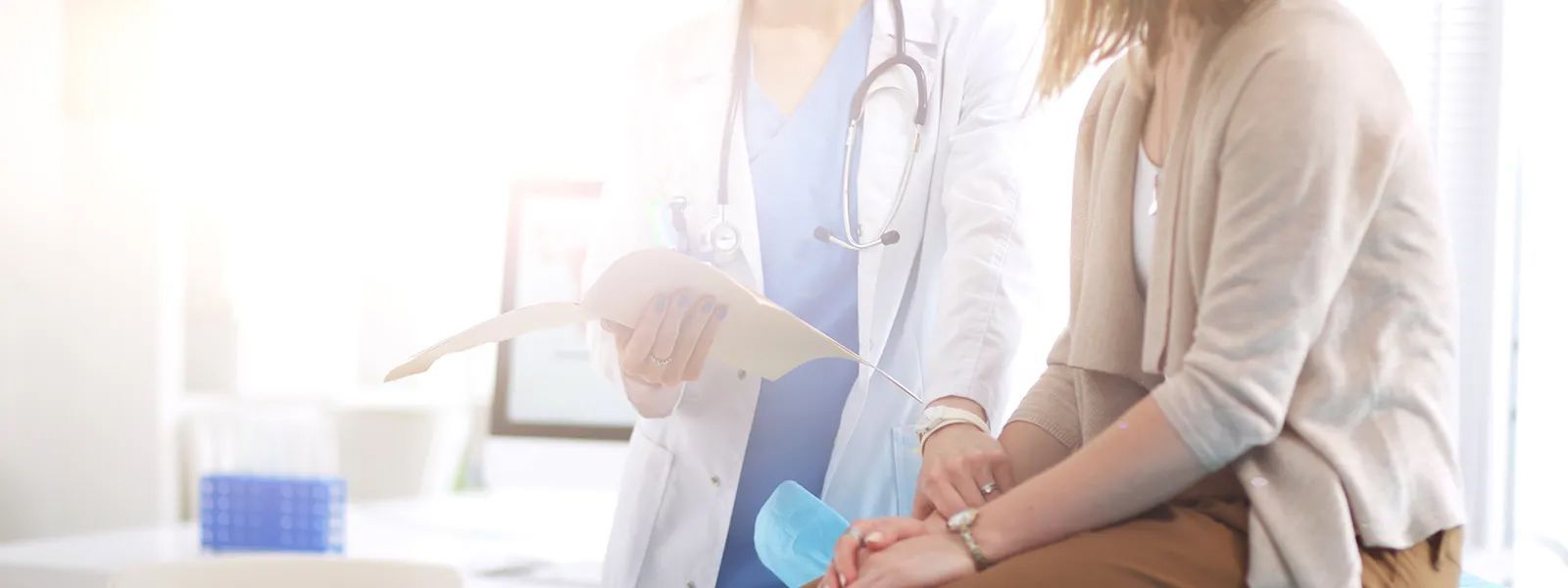A doctor is holding the hand of a patient in a hospital.