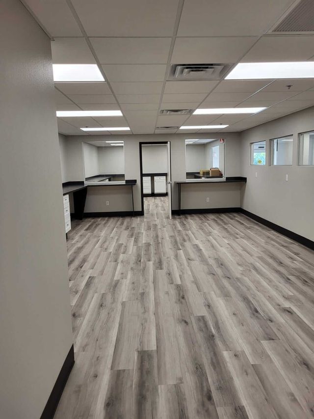 A large empty room with hardwood floors and white walls.