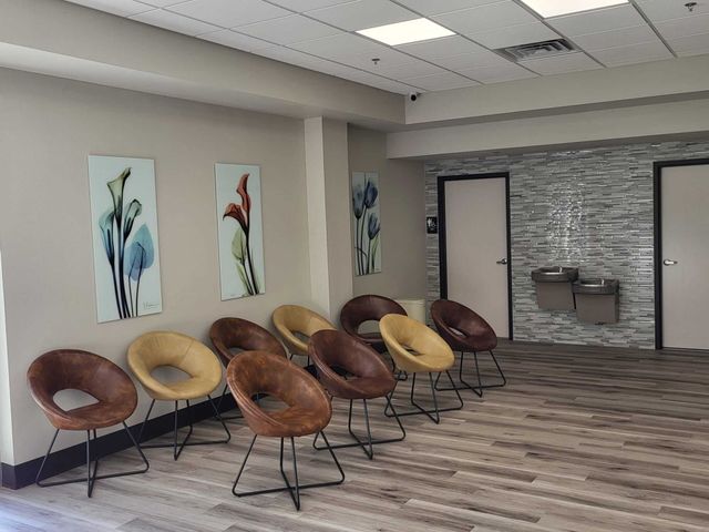 A row of chairs are lined up in a waiting room.