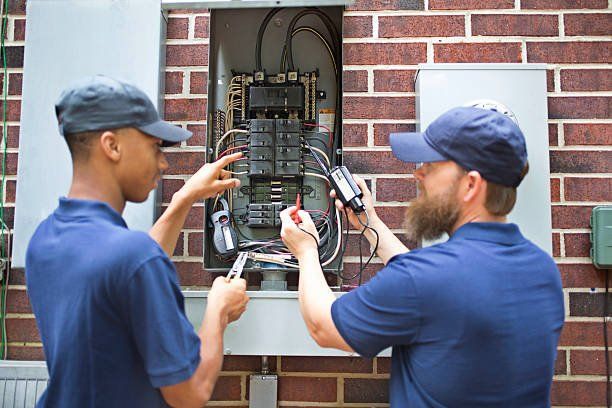 Electricians working on home breaker box