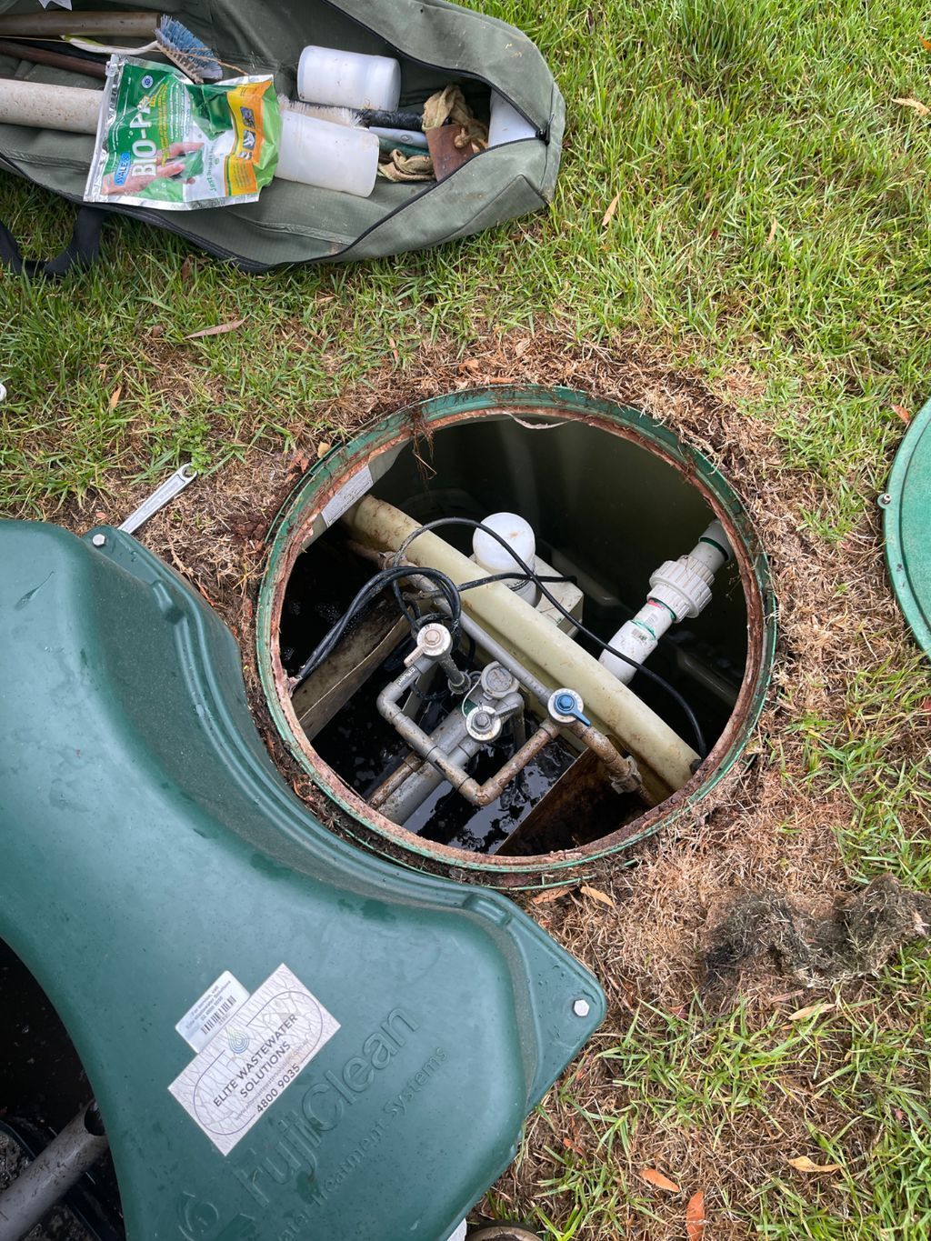 A Couple of Black Tanks are Sitting in a Hole in the Ground — Elite Wastewater Solutions in Wingello, NSW