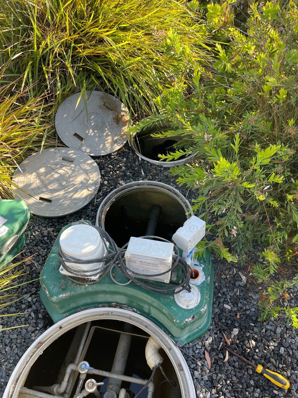 A Large Blue Tank is Sitting in a Hole in the Ground — Elite Wastewater Solutions in Goulburn, NSW