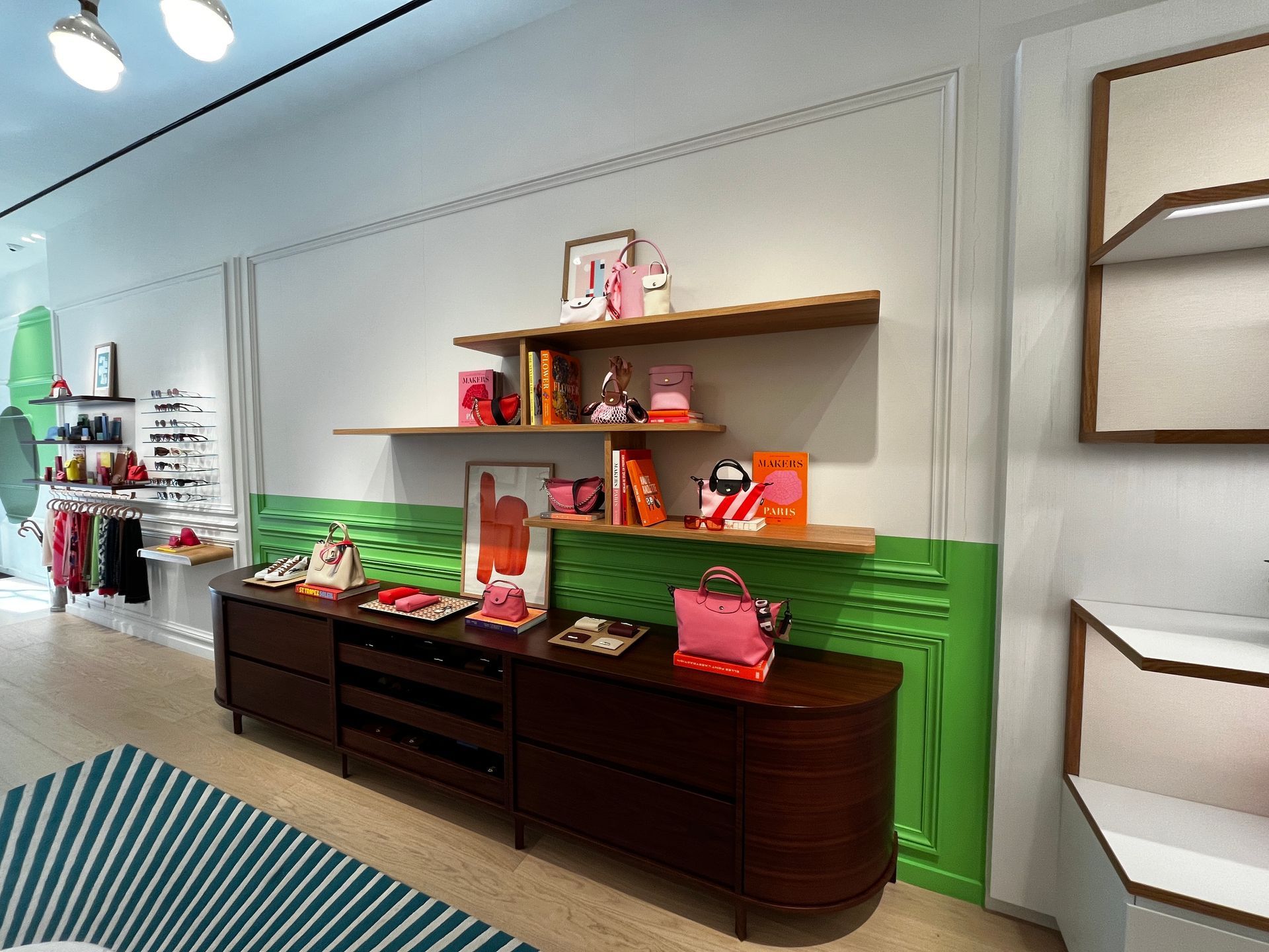 Shelved display in a store aisle with dark wood cabinets and bright green wall accent
