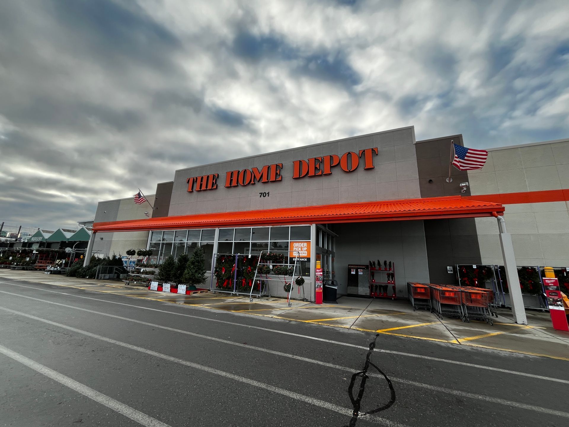 The Home Depot storefront with orange awning and carts outside under a cloudy sky