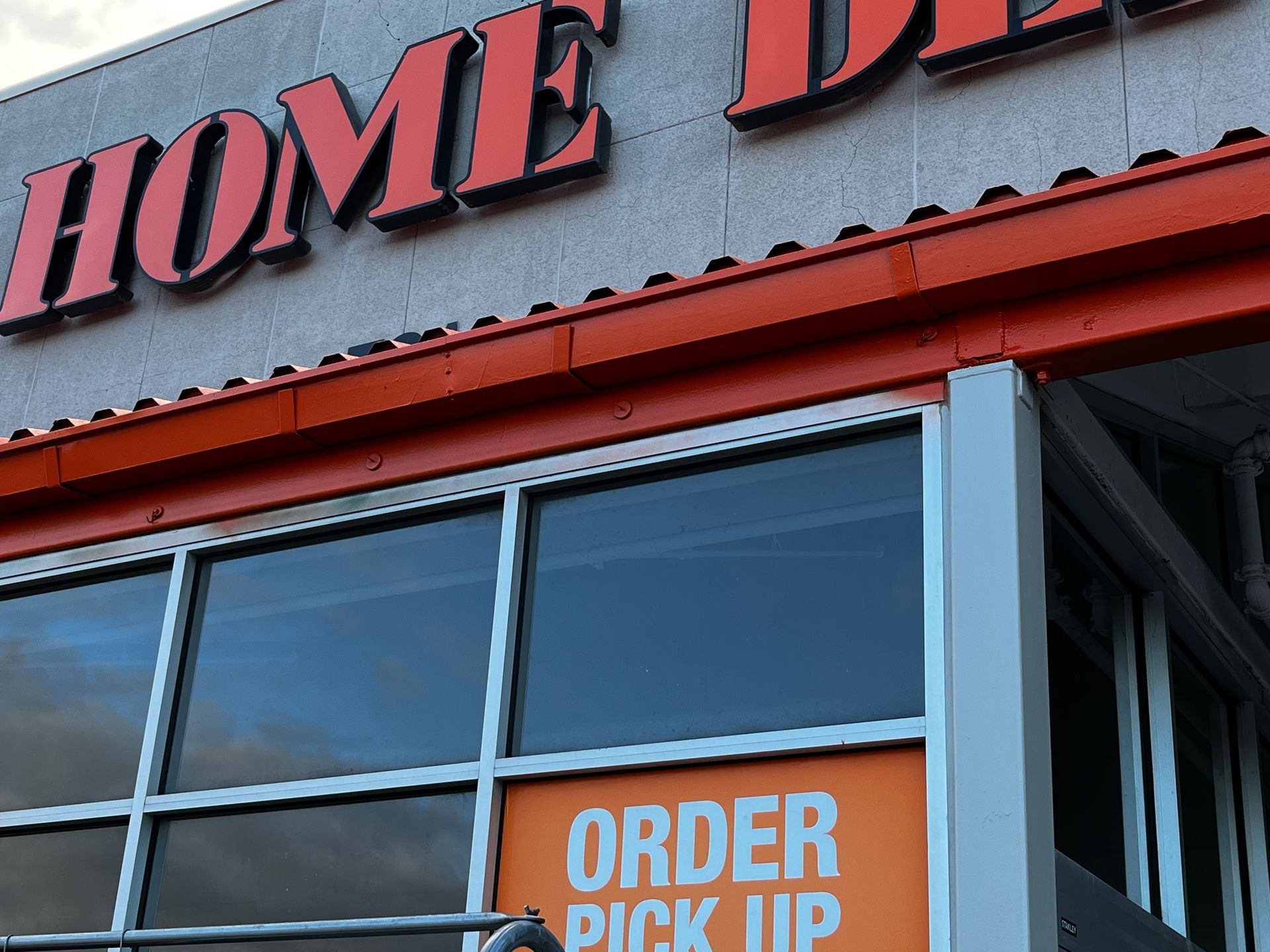 Storefront with red sign above windows and orange “ORDER PICK UP” sign on the door