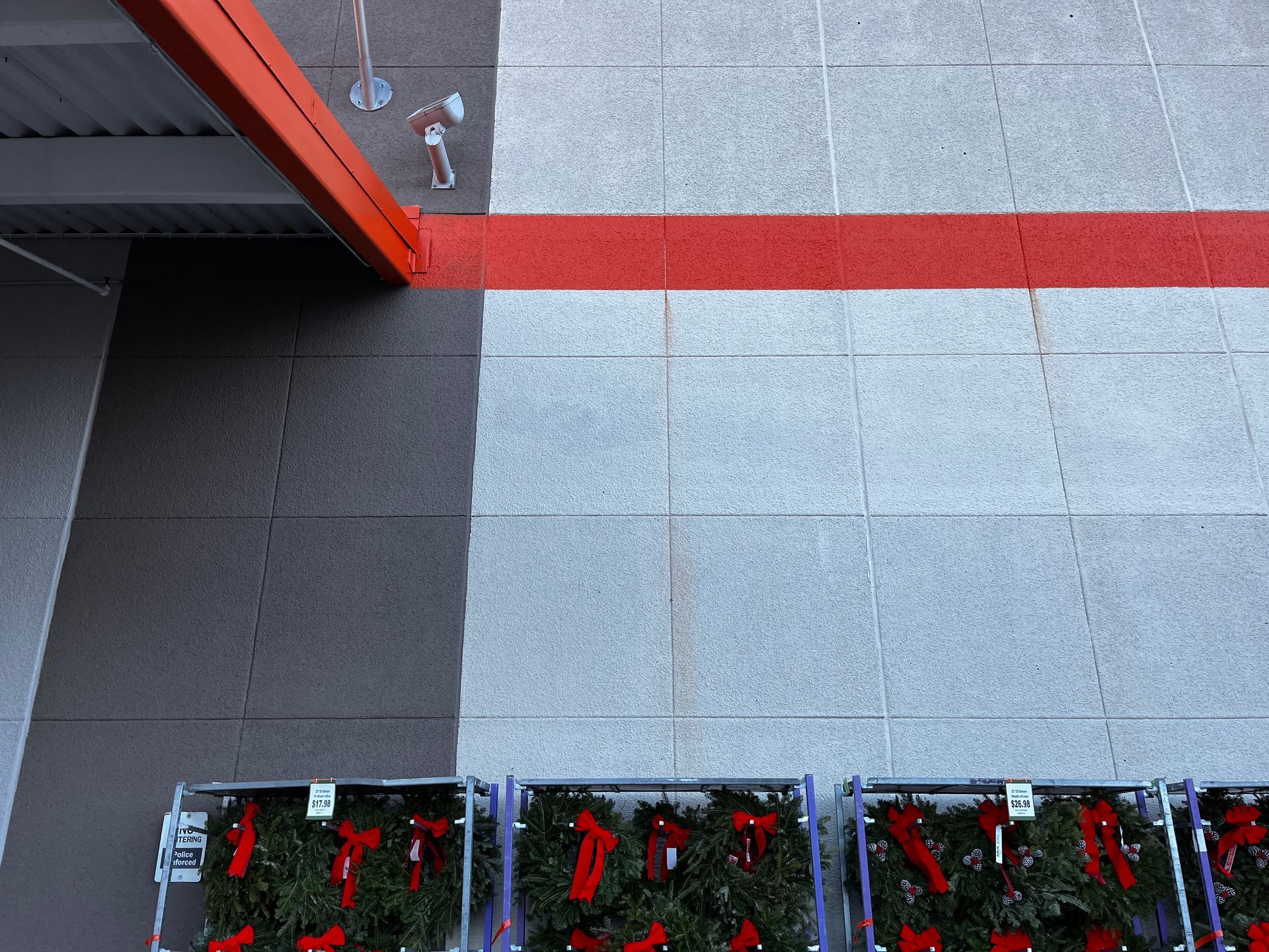 Top-down view of a tiled patio with red and gray sections and several small planter boxes along the bottom edge