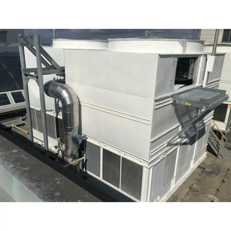 White rooftop HVAC unit with metal ducting and solar panels on a commercial roof