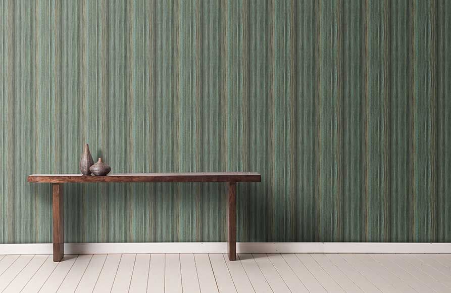 Wooden bench against striped green wallpaper, with a small sculpture on the left side.