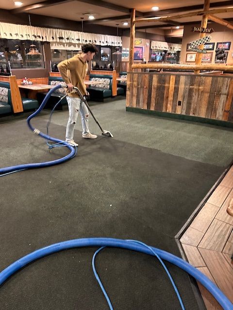 A man is vacuuming the floor of a restaurant