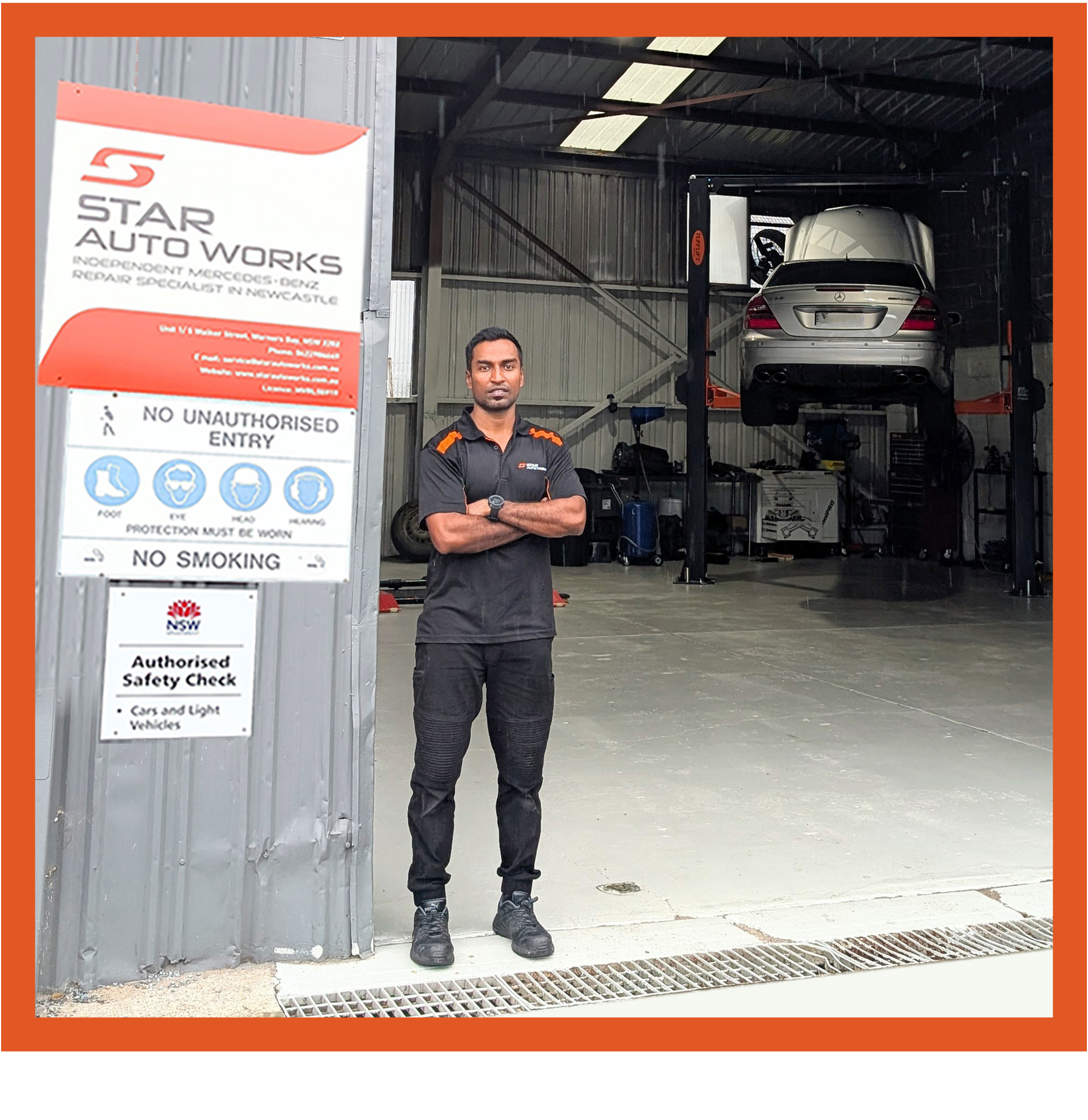 A mechanic stands with arms crossed in front of Star Auto Works, where a car is lifted on a hoist in the workshop.