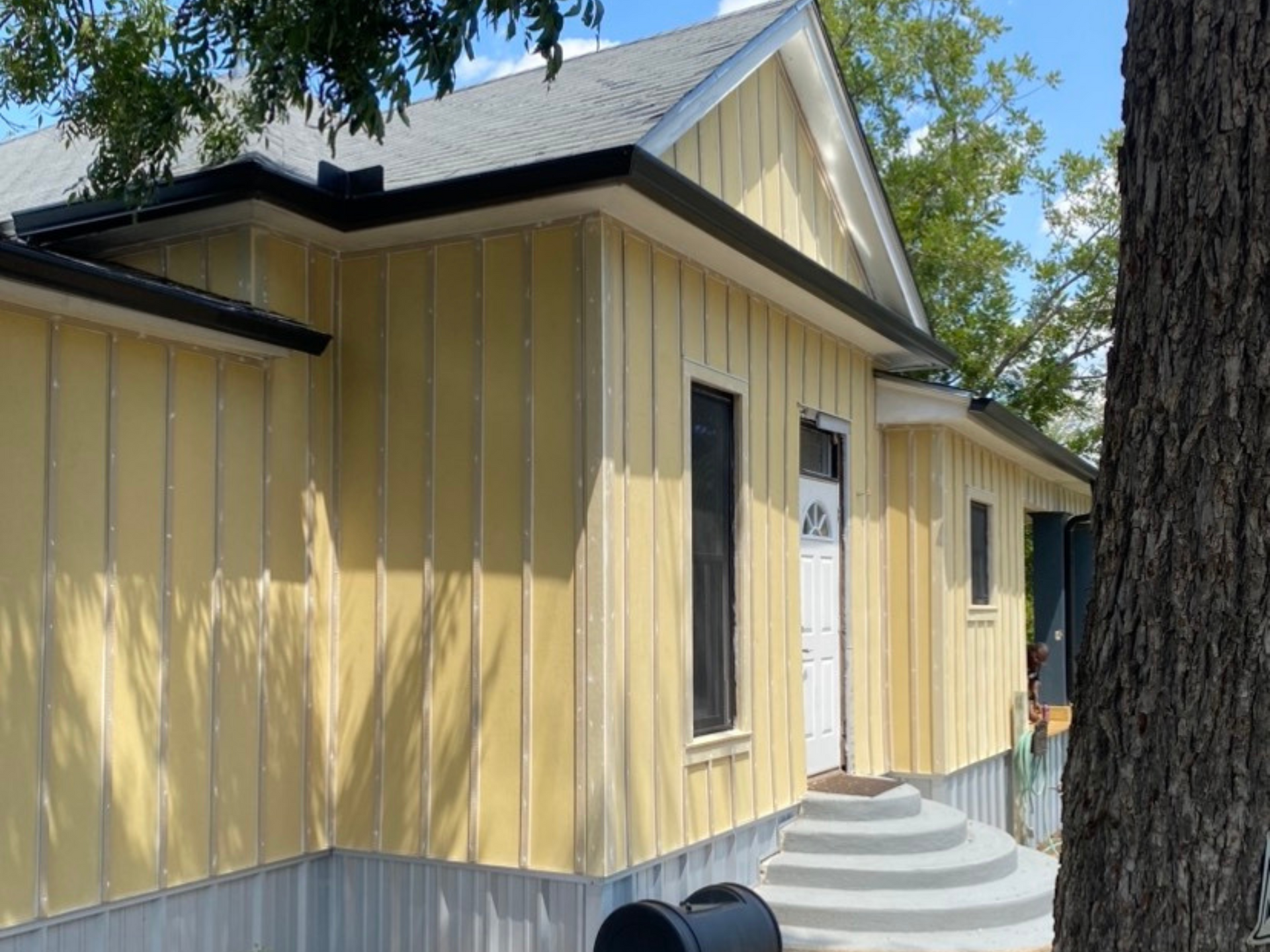 A yellow house with a mailbox in front of it.