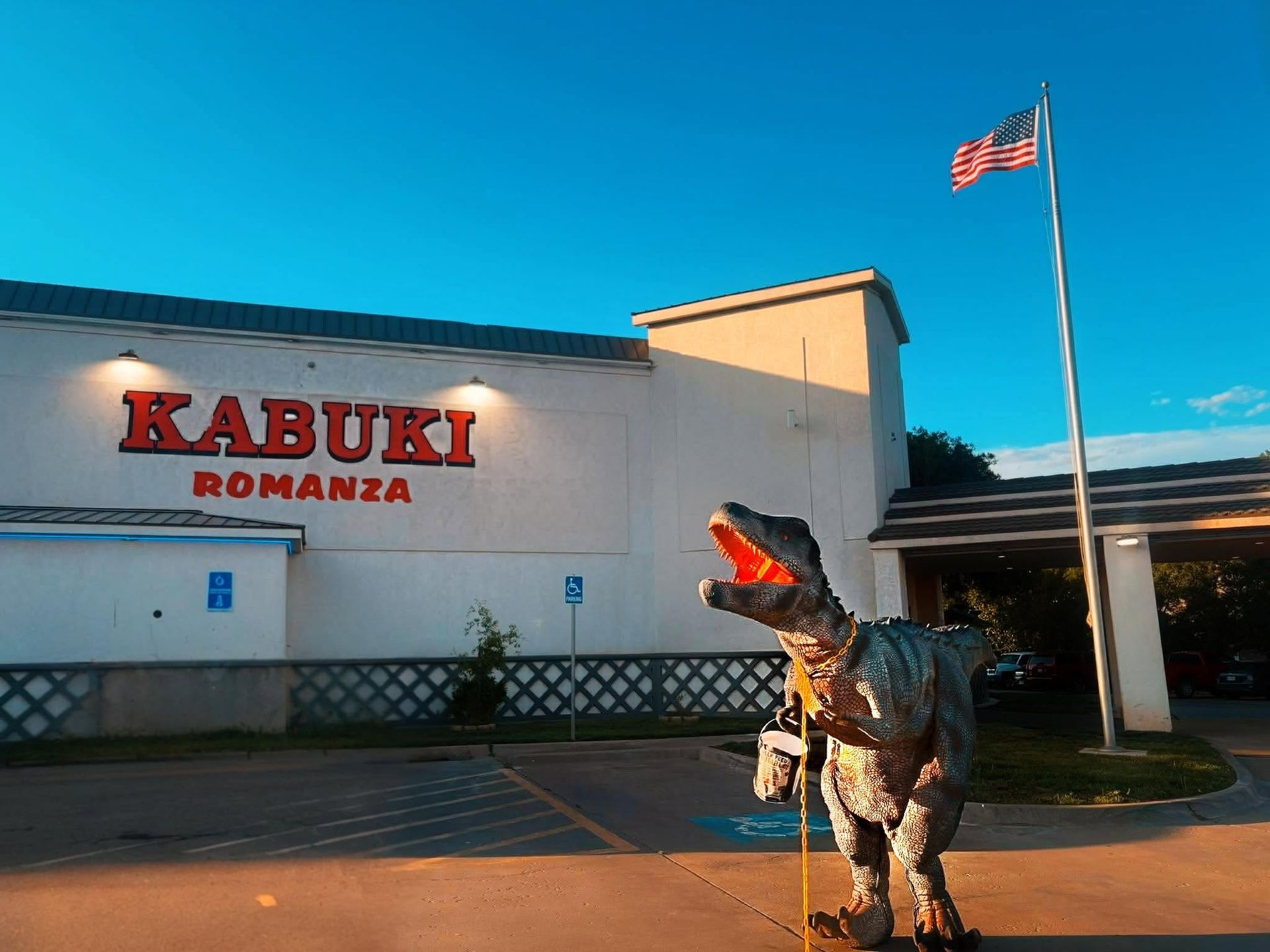 Rabuki Romanza building with a costumed dinosaur performer outside under a blue sky