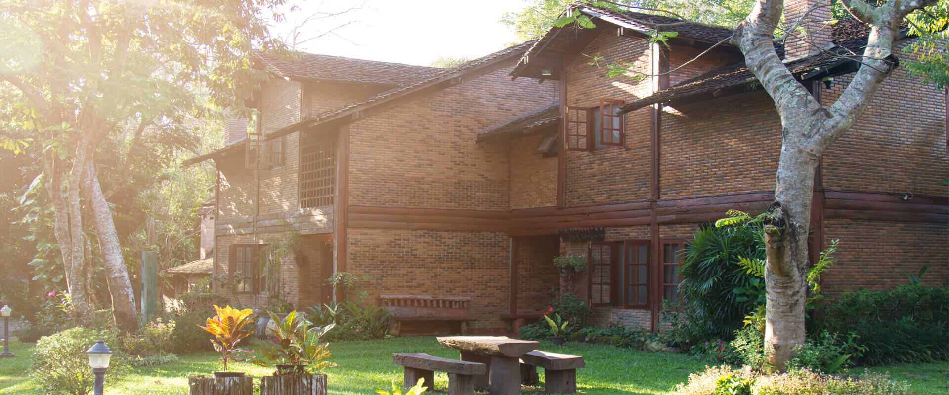 A wooden house with a picnic table in front of it.