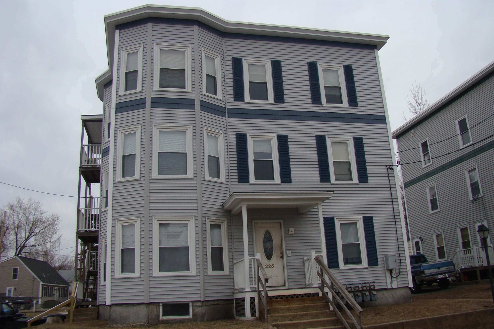 A large white building with black shutters on the windows