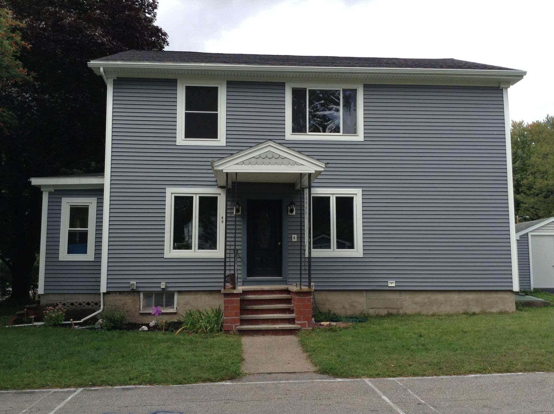 A gray house with white trim and a porch