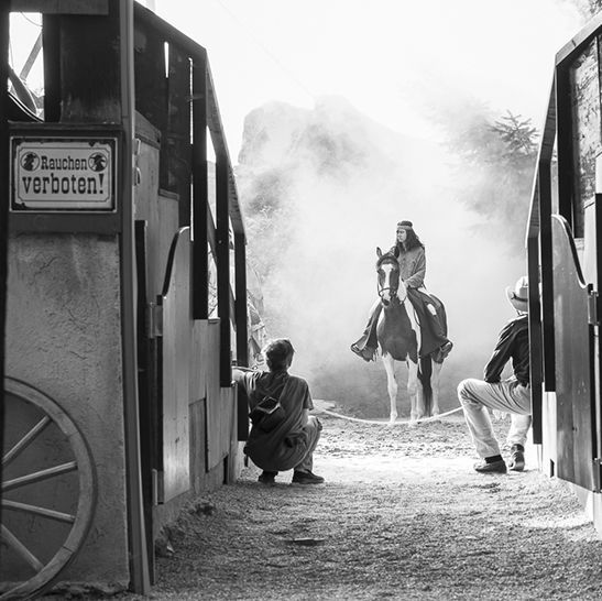 A man is riding a horse in front of a sign that says verboten