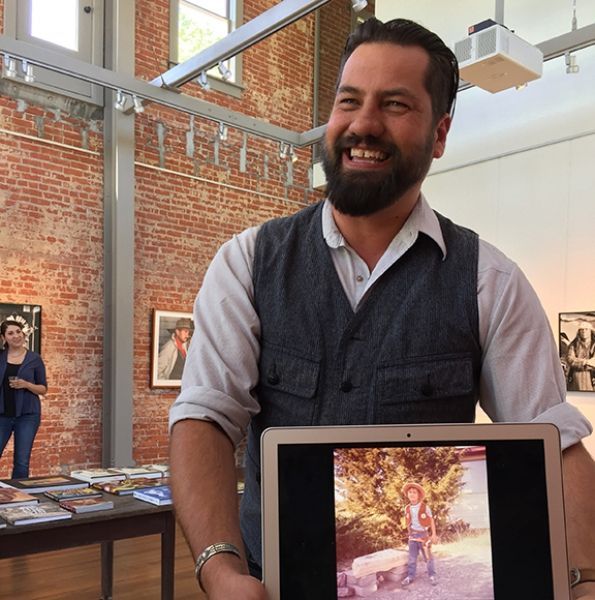 A man holding a laptop with a picture of a child on it