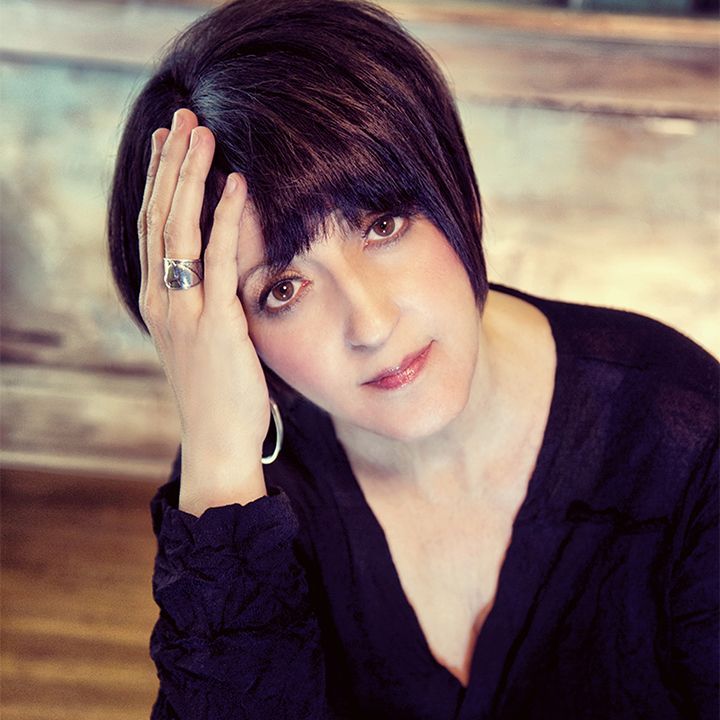 The woman is wearing a black shirt and a ring on her finger.