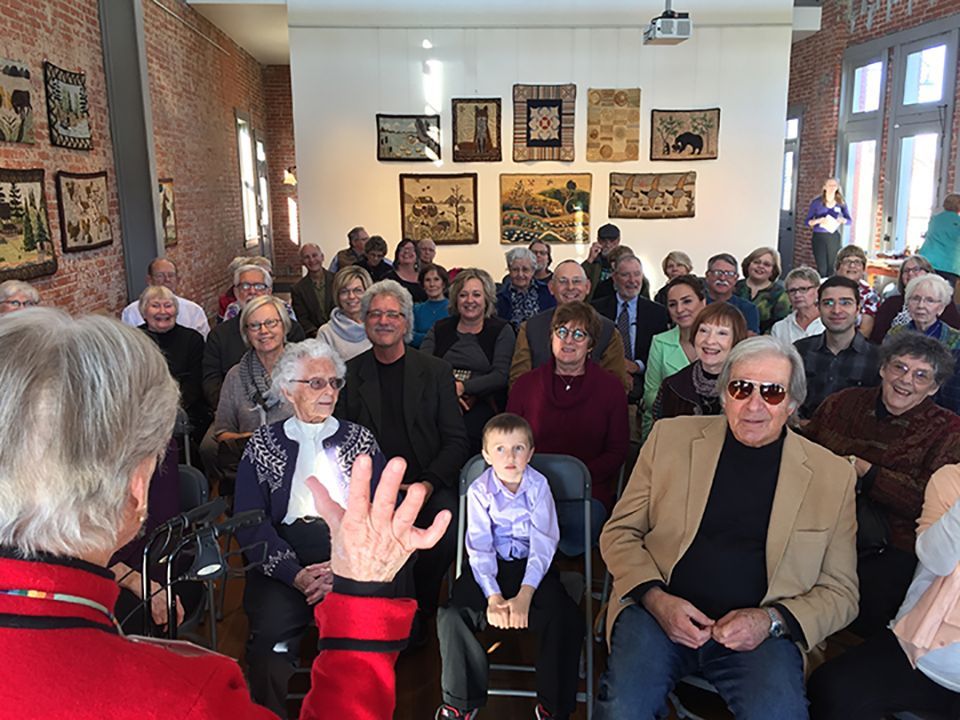 A group of people are sitting in a room watching a presentation.