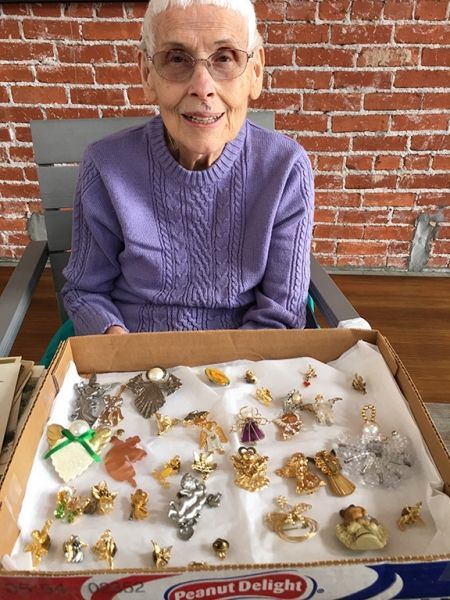 A woman in a purple sweater is sitting in front of a box of peanut delight