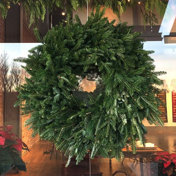 A christmas wreath is hanging from the ceiling in a room.