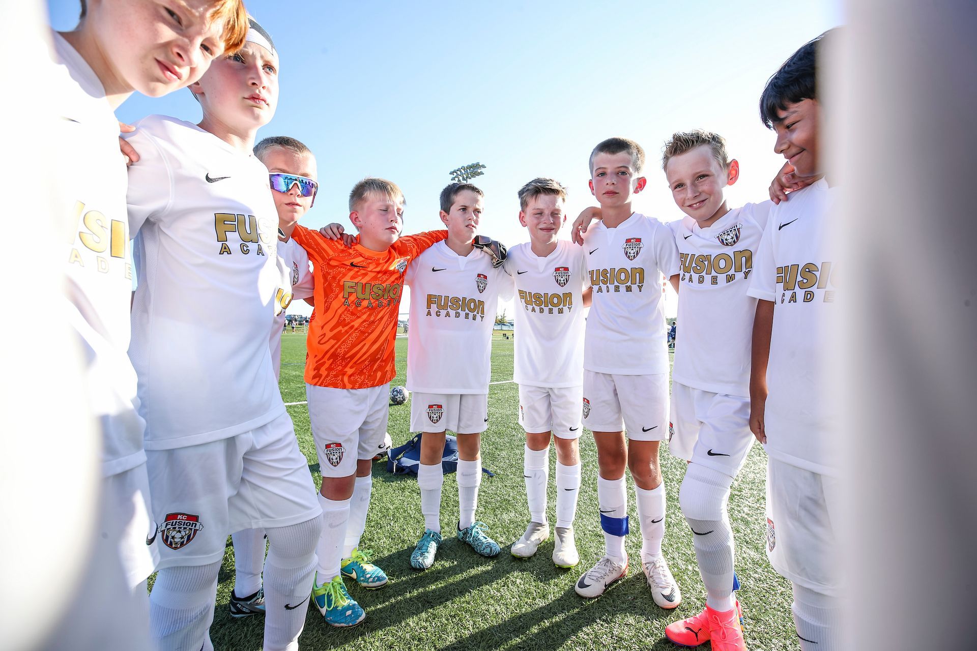 A group of youth boy soccer players for KC Fusion Soccer Club standing in a huddle
