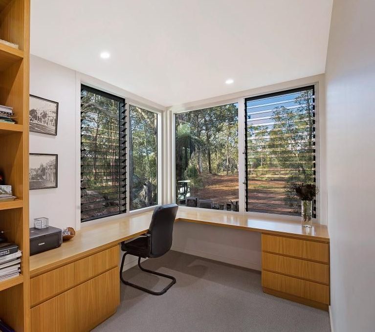 A Home Office with A Desk, Chair, Shelves and Windows — Grainger Windows & Doors in Ballina, NSW