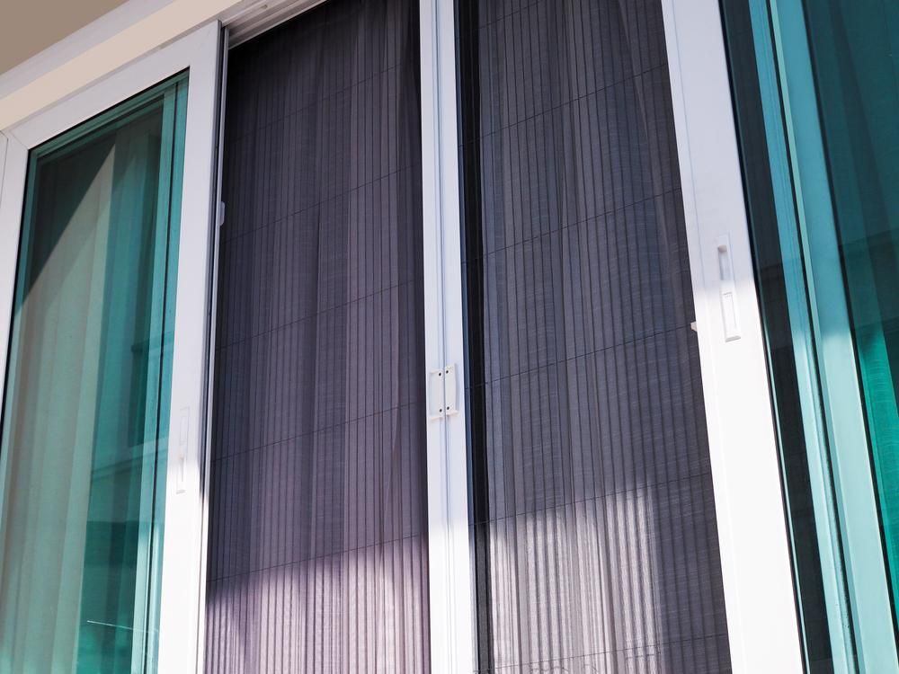 A Close up Of a Sliding Glass Door with A Screen on It — Grainger Windows & Doors in Ballina, NSW