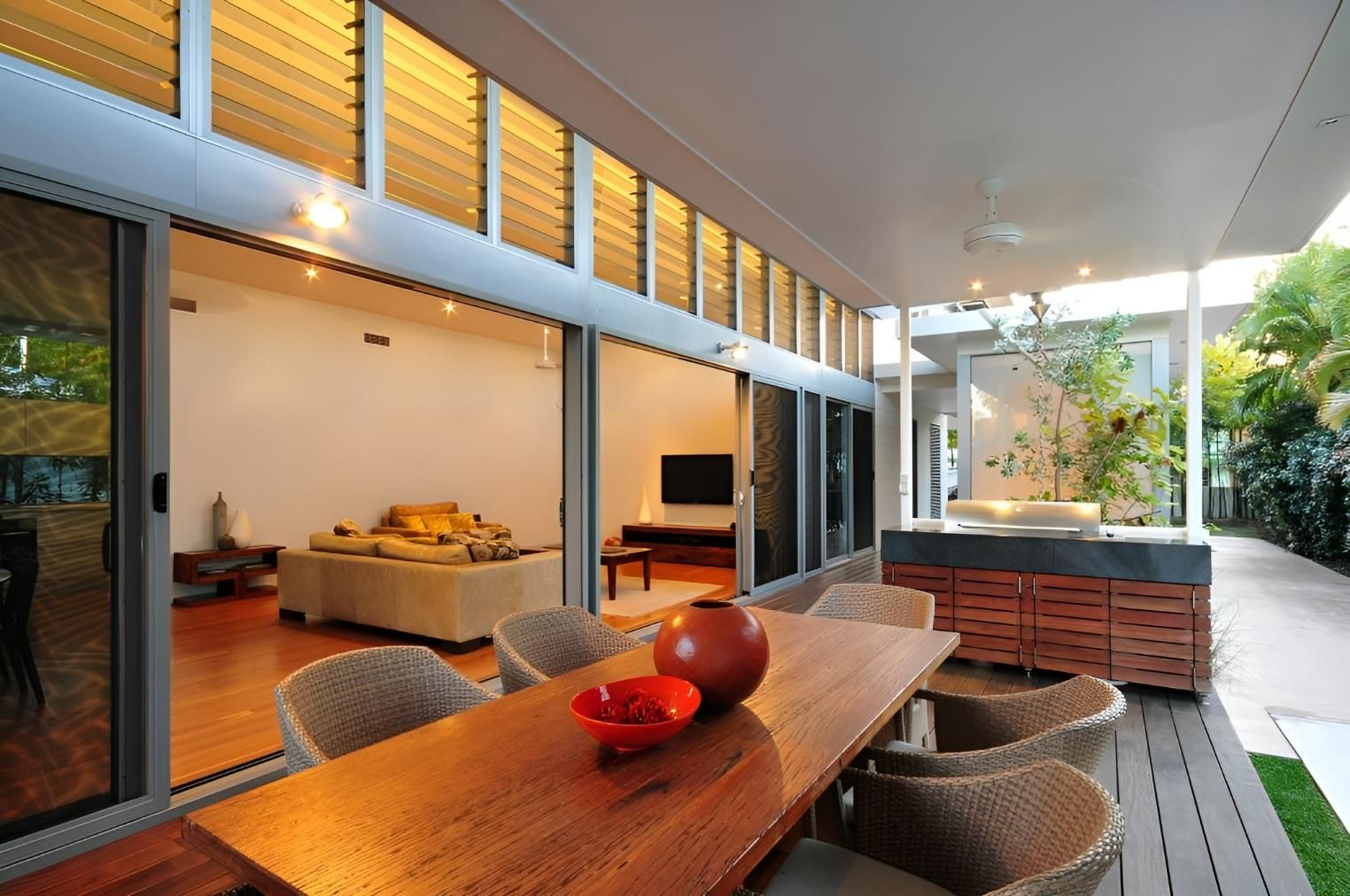 A Wooden Table with Wicker Chairs in Front of A Living Room — Grainger Windows & Doors in Ballina, NSW
