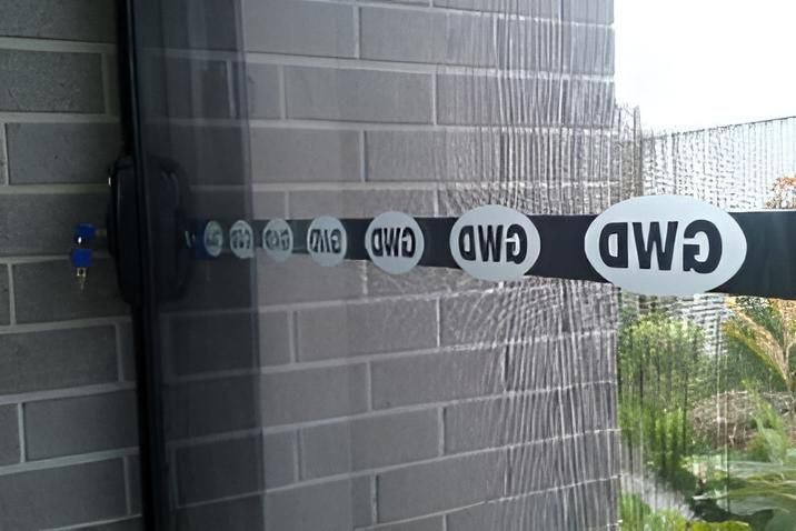 A Close Up of a window with GWD writing across window — Grainger Windows & Doors in Ballina, NSW