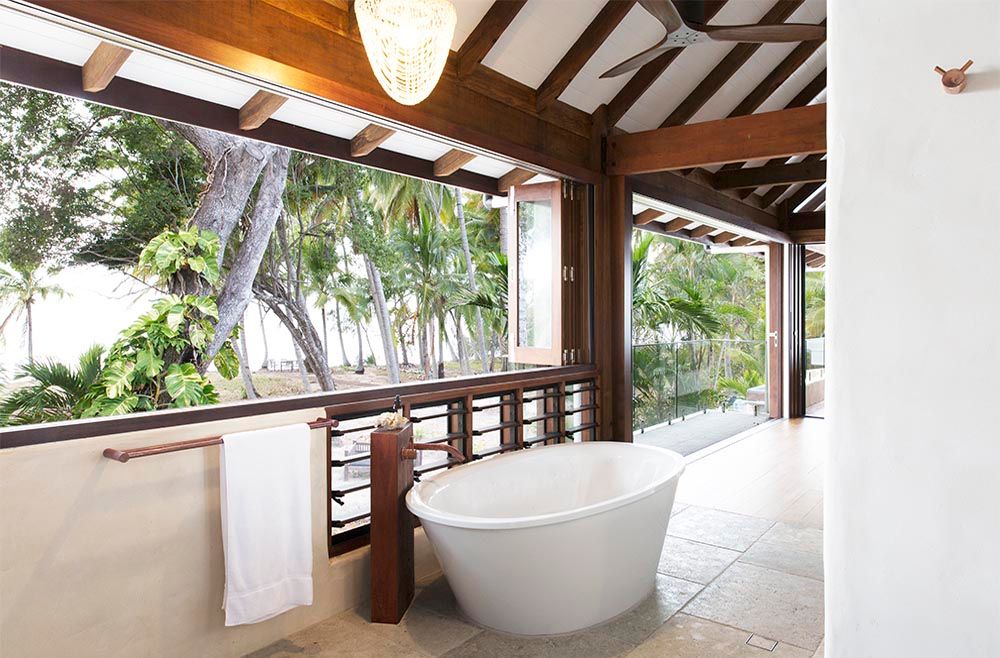 A Bathroom with A Bathtub and A Window with Trees in The Background — Grainger Windows & Doors in Ballina, NSW