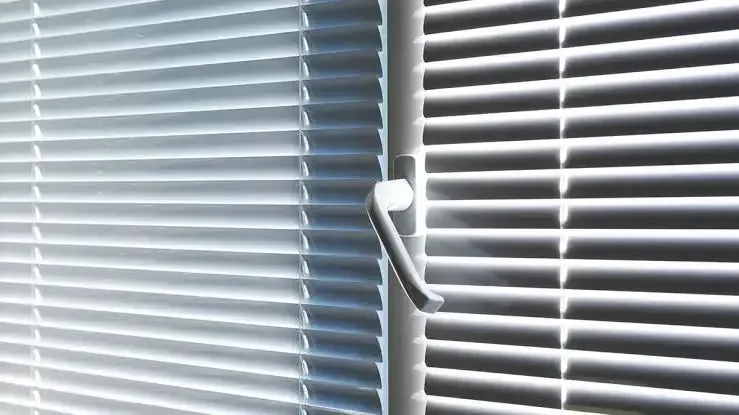A Close up Of a Window with Blinds and A Handle — Grainger Windows & Doors in Ballina, NSW