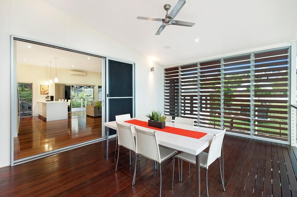 A Dining Room with A Table and Chairs and A Ceiling Fan — Grainger Windows & Doors in Ballina, NSW