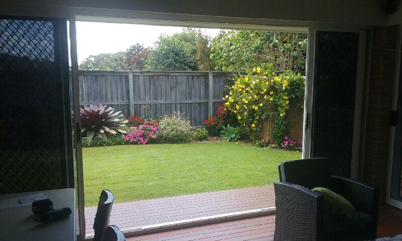 A View of A Backyard Through a Sliding Glass Door — Grainger Windows & Doors in Ballina, NSW
