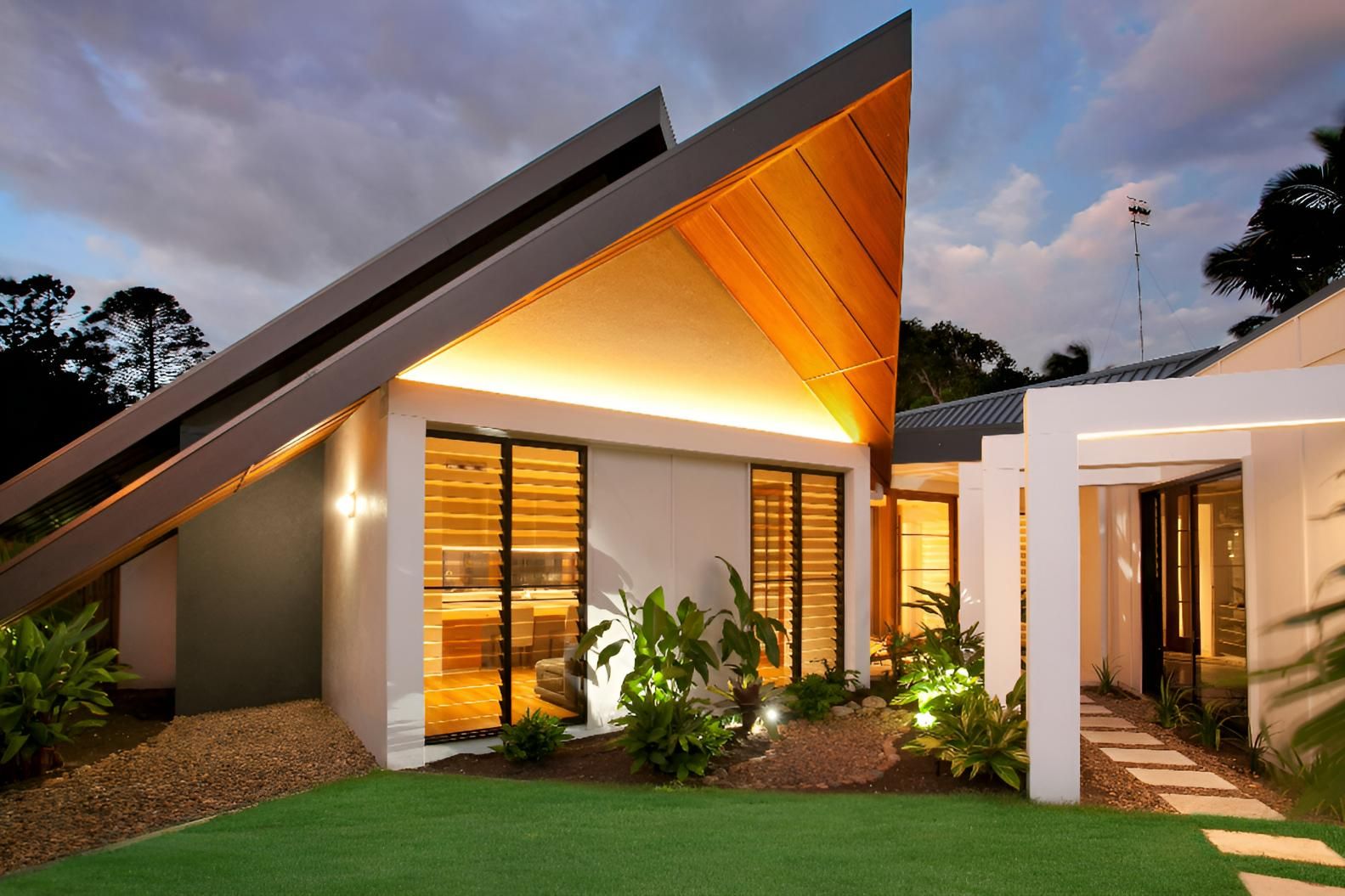 A Modern House with A Triangle Shaped Roof and A Walkway Leading to It — Grainger Windows & Doors in Ballina, NSW