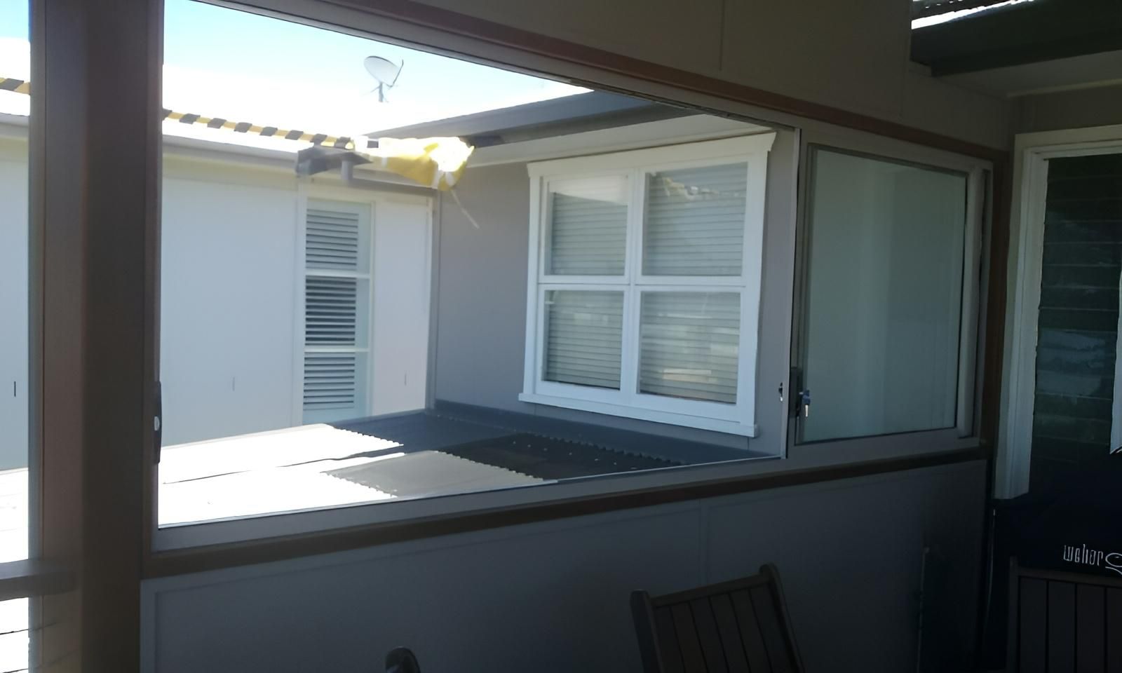 A Porch with A Window and A Chair on It — Grainger Windows & Doors in Lennox Head, NSW