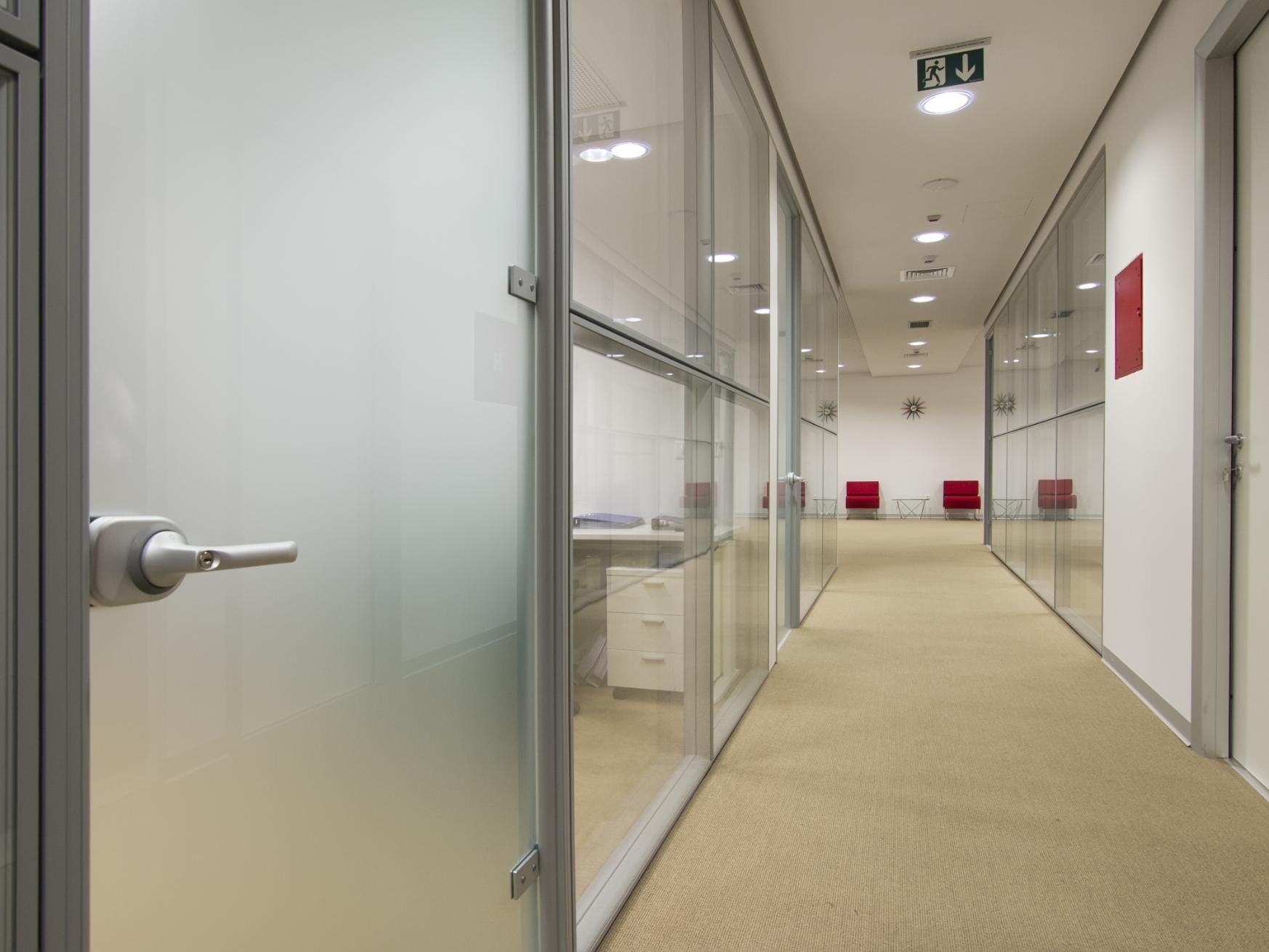 A Long Hallway in An Office Building with Glass Walls — Grainger Windows & Doors in Ballina, NSW