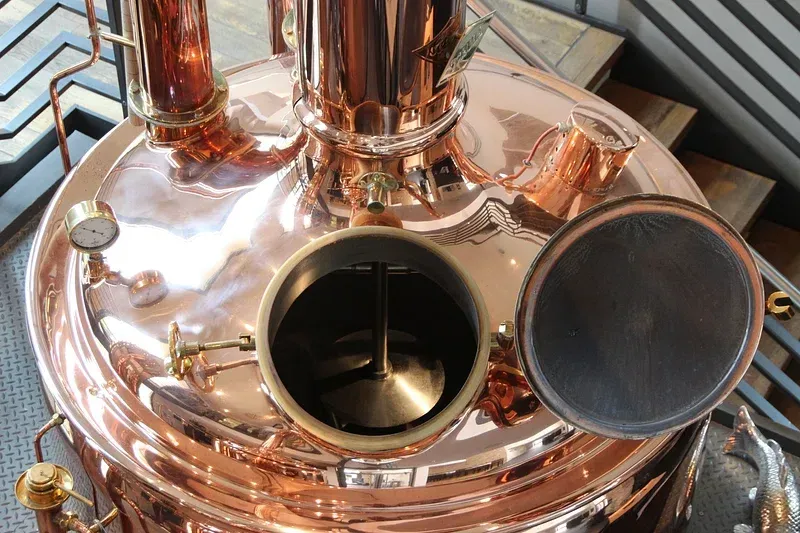 A close up of a copper pot with the lid open