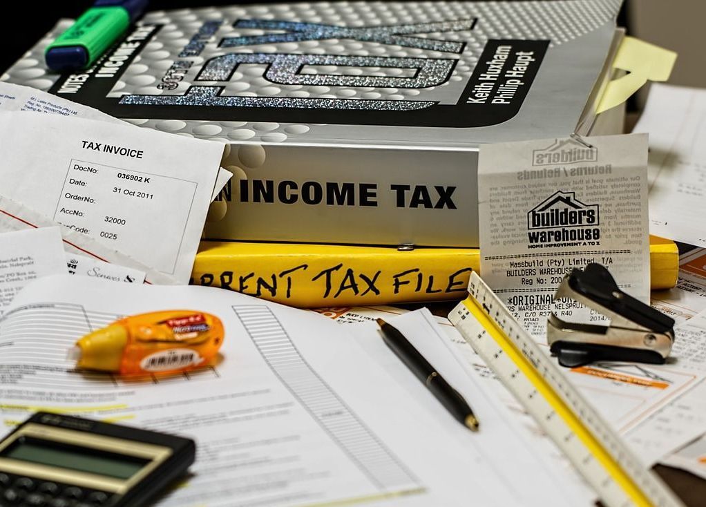 A pile of papers with a book titled income tax on top