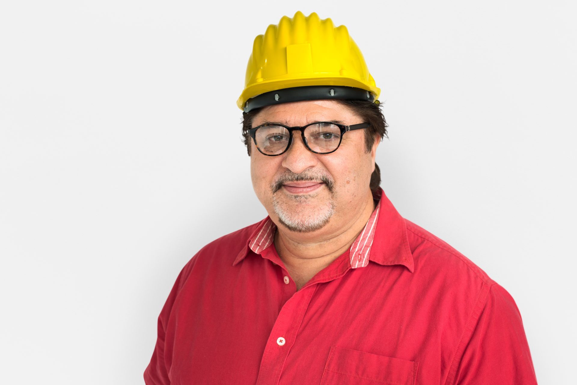 A man wearing a red shirt and a yellow hard hat.