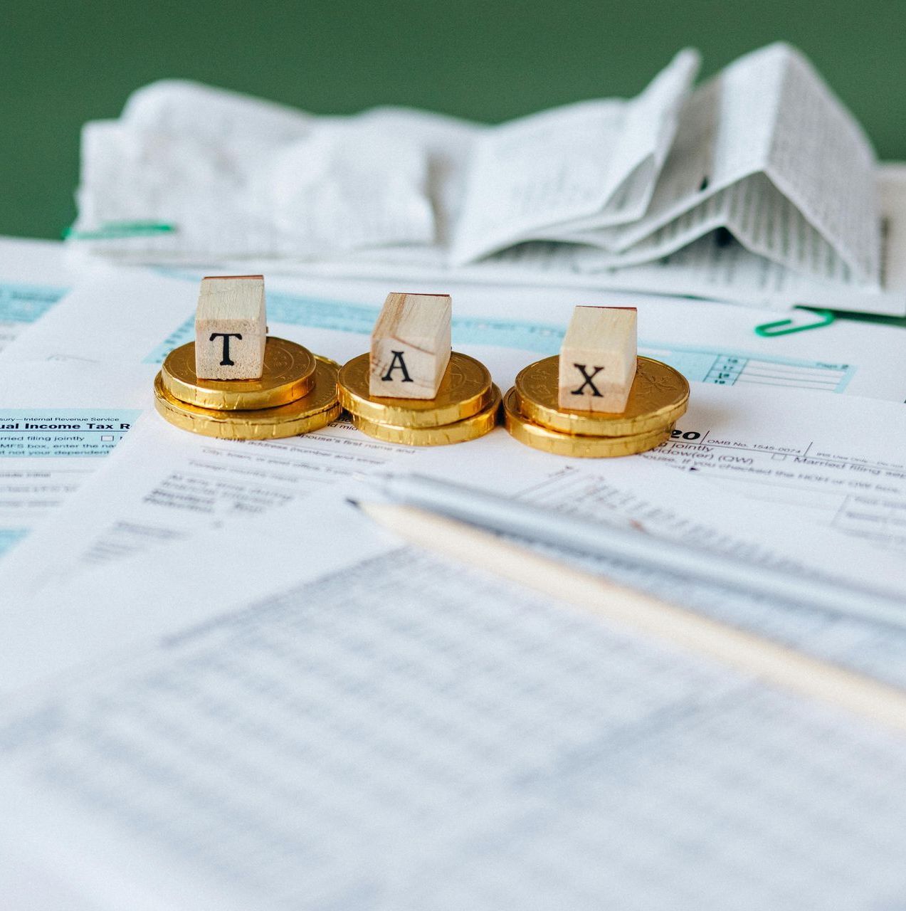 Three stacks of gold coins with the letters tax on them